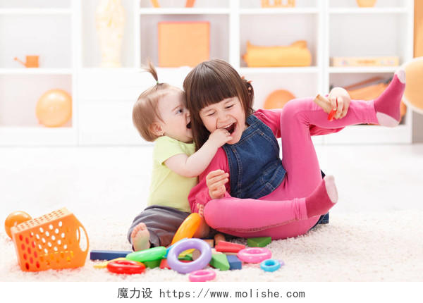 小女孩和她的妹妹玩玩具微笑的小女孩